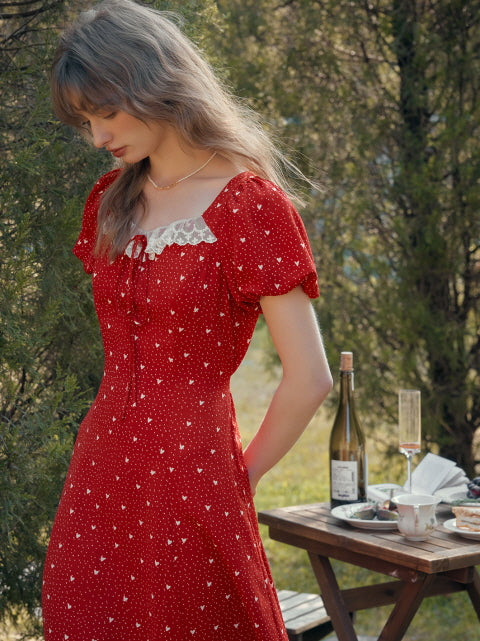 A romantic red retro dress with lace trim worn in a sunlit garden, perfect for casual summer outfits with vintage charm.