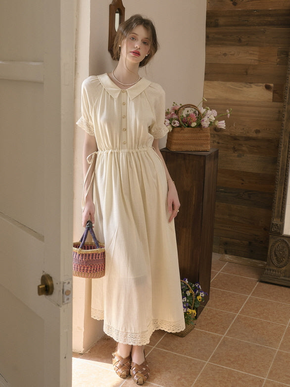 A cottagecore aesthetic outfit featuring a vintage-inspired ivory dress with lace trim and a gathered waist, styled with a woven basket bag for a charming retro look.