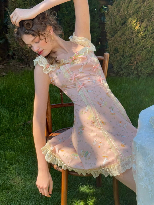 Whimsical pink lace dress with floral details and ribbon bows, as a young woman leans back gracefully on a wooden chair, evoking a dreamy, cottagecore aesthetic.
