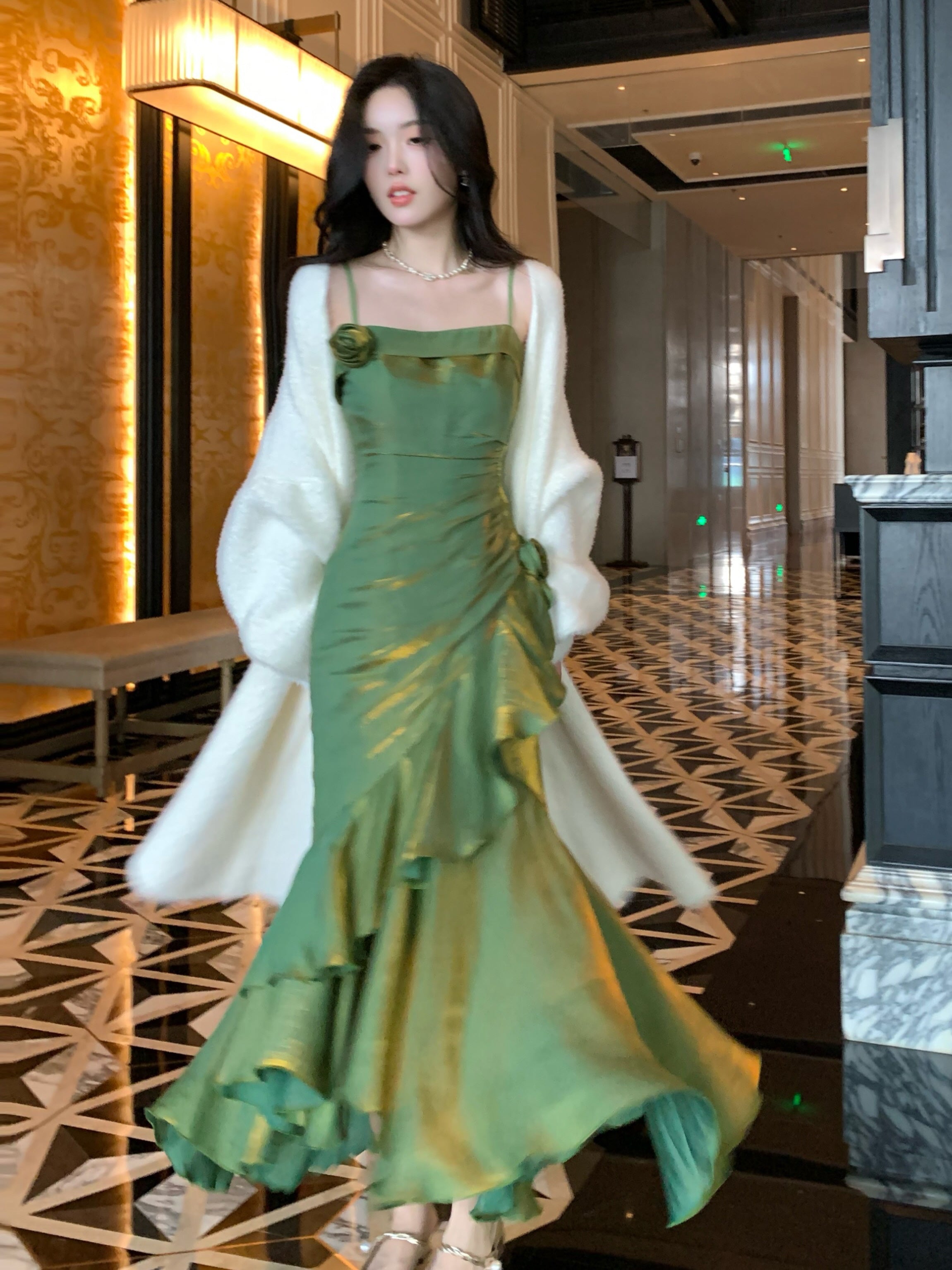 Vintage-inspired green ruffle dress with floral accent, styled with soft curls and pearl necklace.