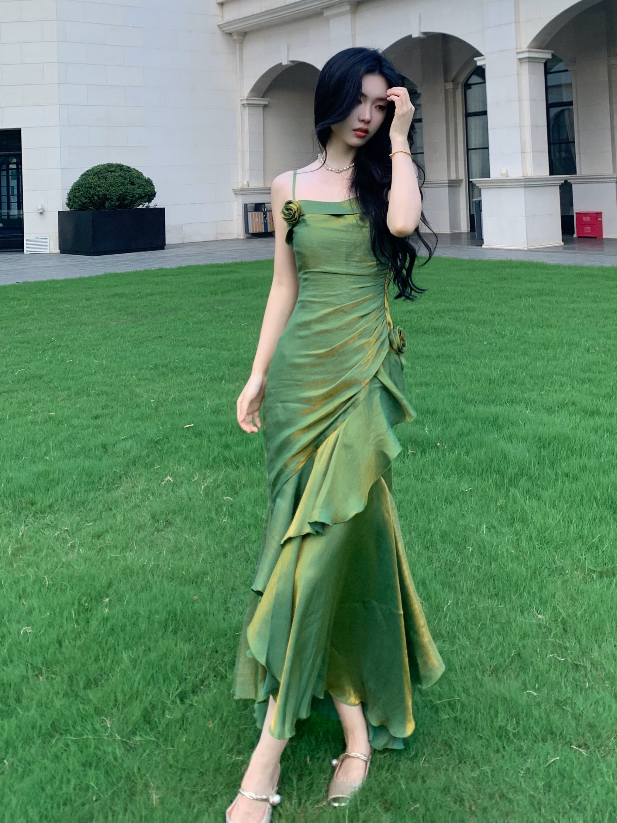 Feminine green gown with delicate straps, paired with cozy white outerwear, in a café terrace.