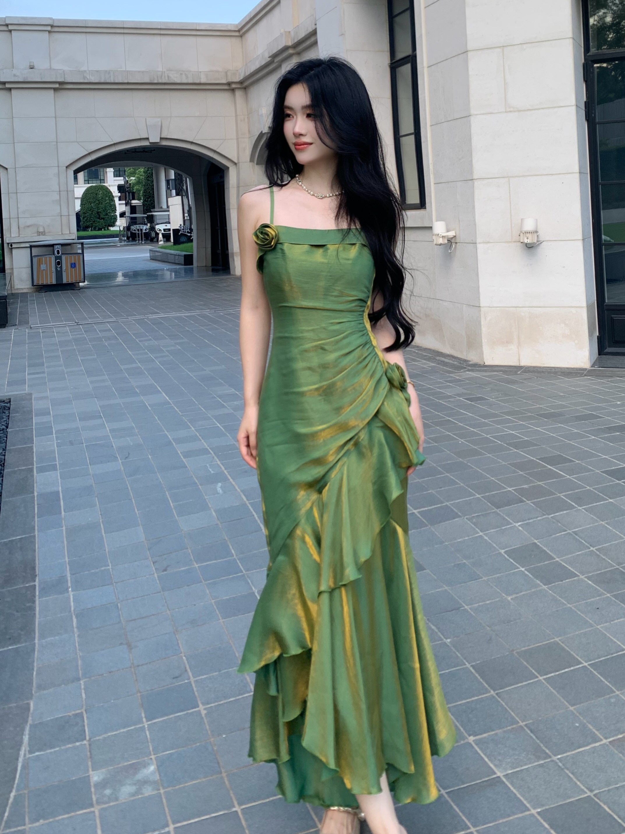 Elegant green satin dress with rose details, captured mid-walk in a romantic castle.