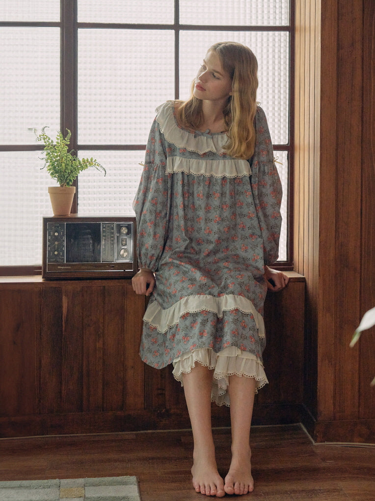 A dreamy, vintage-inspired blue floral nightgown with layered lace hem, styled against a nostalgic wooden backdrop for a cottagecore aesthetic.