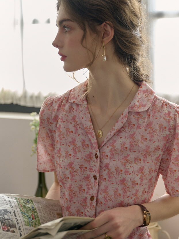 Close-up of a pink floral cottagecore dress with wooden buttons, capturing a casual and dreamy countryside-inspired atmosphere.