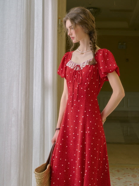 A beautiful red retro dress styled indoors with puff sleeves and lace detail, ideal for aesthetic and feminine summer looks.