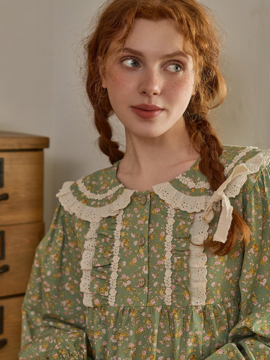 A charming, vintage-inspired floral green dress with lace ruffle details and button accents, capturing a fairytale cottagecore look.