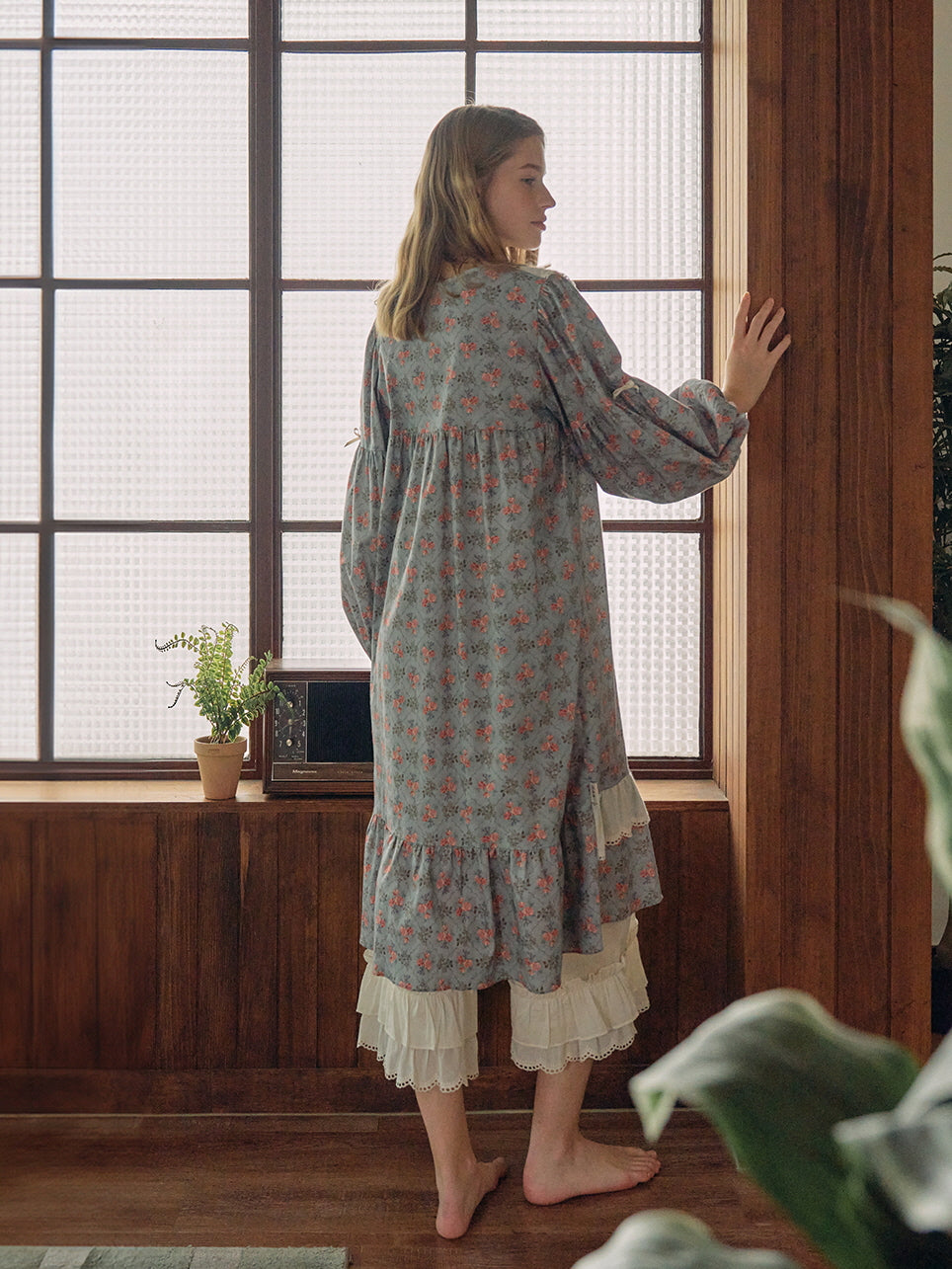 A serene back view of a blue floral nightgown with layered lace hem, styled in a nostalgic, vintage-inspired setting for a dreamy fairytale vibe.