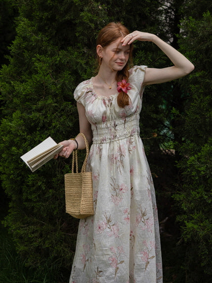 A woman shielding her eyes from the sun while wearing a floral cottagecore dress with smocked waist and ruffled sleeves. Romantic, fairytale aesthetic.