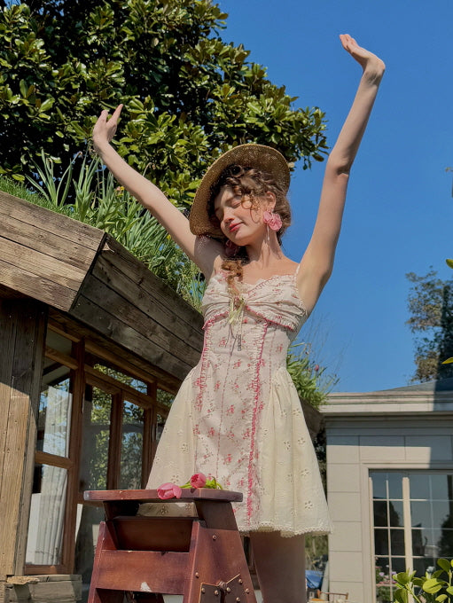 Romantic coquette floral mini dress with lace accents and bow detail, styled with a straw hat and vintage earrings. Dreamy summer look with a playful, carefree vibe, perfect for fairytale-inspired aesthetics