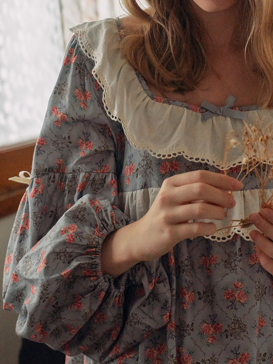A close-up of a blue floral nightgown with lace-trimmed ruffles and puff sleeves, capturing the delicate, vintage-inspired detailing.