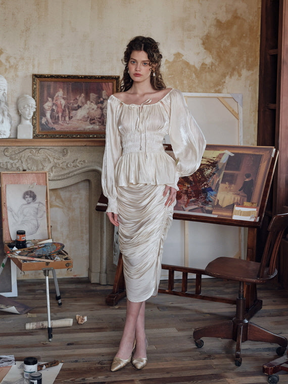 Cream ruched satin skirt paired with glossy vintage-style blouse, photographed in a classic artist’s studio – elegant fairytale-inspired women’s outfit for romantic fashion lovers