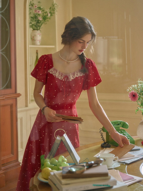 A dreamy retro dress in red, styled in a vintage study with old letters and soft sunlight, creating a nostalgic aesthetic.