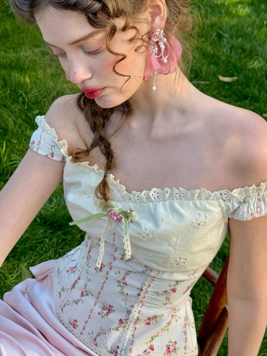 Close-up of vintage floral corset top with lace trim and green ribbon bow, paired with a pastel pink satin skirt – romantic fairytale cottagecore fashion