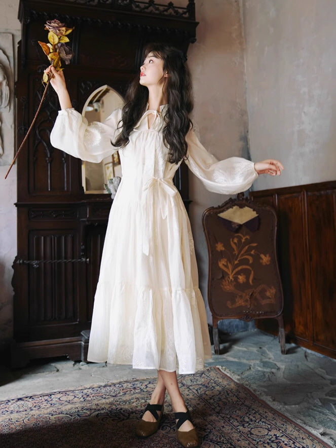 A woman wearing a romantic fairytale white dress, raising a dried flower in a dreamy vintage aesthetic setting.