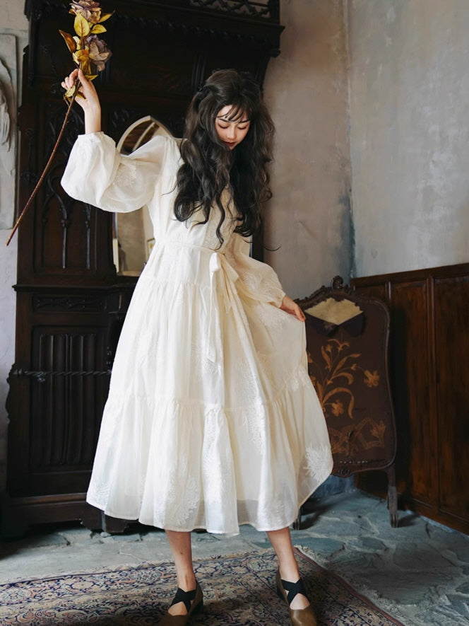 Aesthetic fairytale dress outfit featuring a vintage white long dress with delicate embroidery, as the model poses gracefully indoors with a soft, fantasy atmosphere.