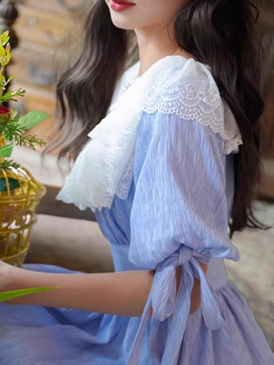 Close-up of a fantasy vintage blue dress featuring a romantic white lace collar and ribbon-tied puff sleeves, capturing a dreamy, fairytale-like outfit vibe.