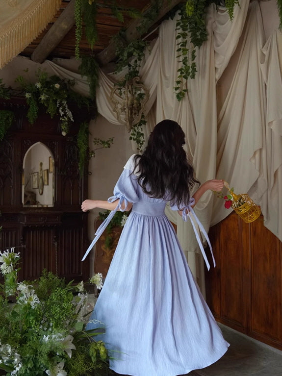 Aesthetic vintage blue fairytale dress flowing gracefully as the model walks through a fantasy-inspired, floral room.