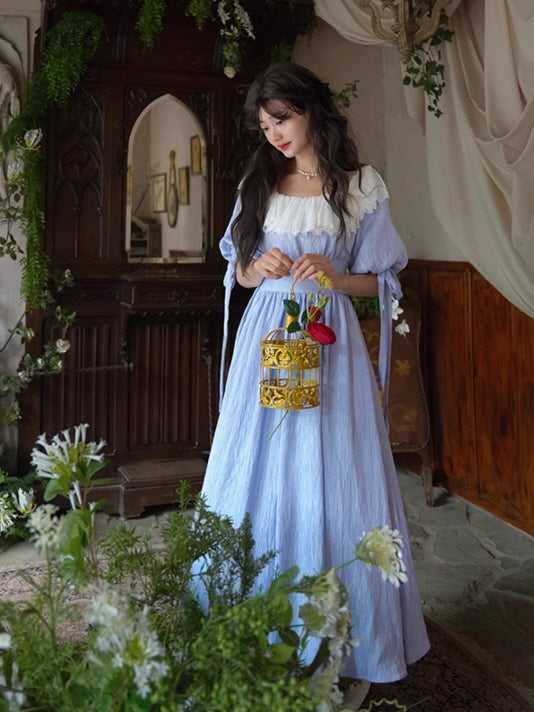 Romantic fairytale blue dress featuring vintage lace accents, captured in a fantasy-like interior full of greenery and flowers.