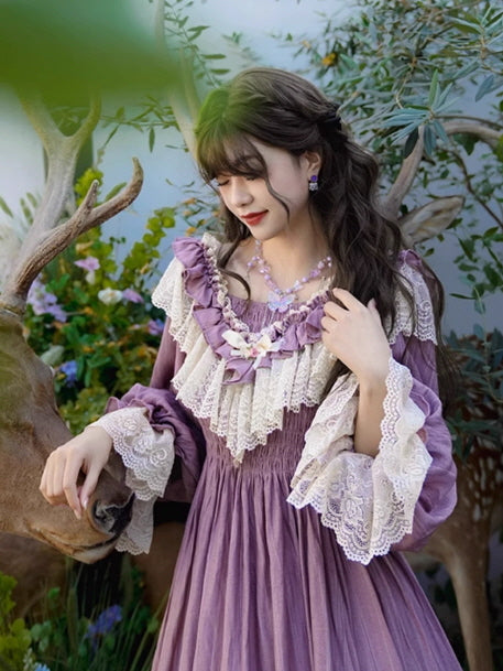 Woman wearing a vintage fantasy purple dress with layered lace details, tilting her head gently beside a deer statue, creating a dreamy fairytale aesthetic outfit.