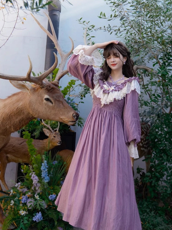A model in a fairytale-inspired purple vintage dress with ruffled lace details, posing gracefully beside deer statues in a lush, fantasy garden setting. Fantasy, aesthetic, vintage outfits