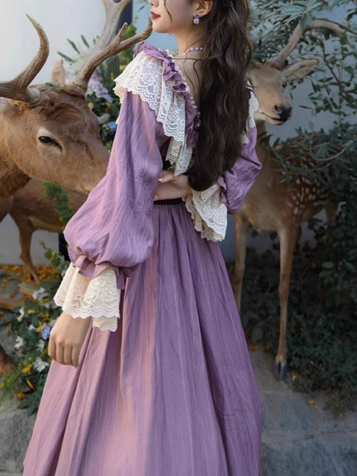 A woman in a fairytale-inspired vintage purple dress with ruffled lace details, standing beside deer statues, showcasing an elegant fantasy aesthetic.