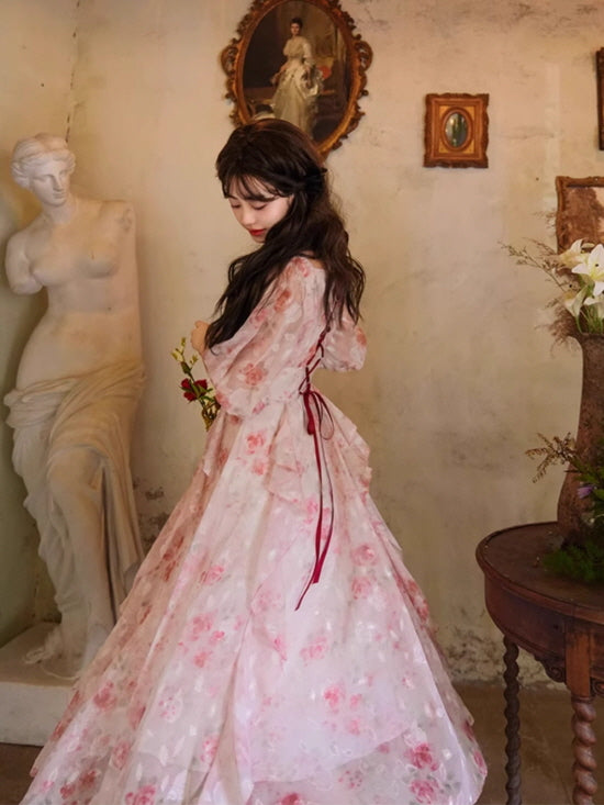 Side view of a flowing pink floral dress with a ribbon lace-up back and layered skirt, creating a whimsical cottagecore silhouette.