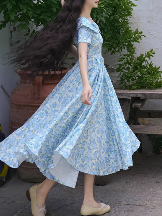 Side view of a blue floral gown in motion, showcasing its twirl-worthy silhouette and soft, romantic cottagecore style.