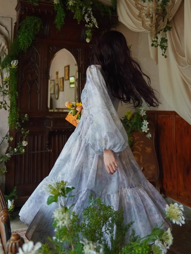 Back view of a flowing lavender floral dress with voluminous sleeves and tiered layers, evoking a dreamy, ethereal fairycore look.