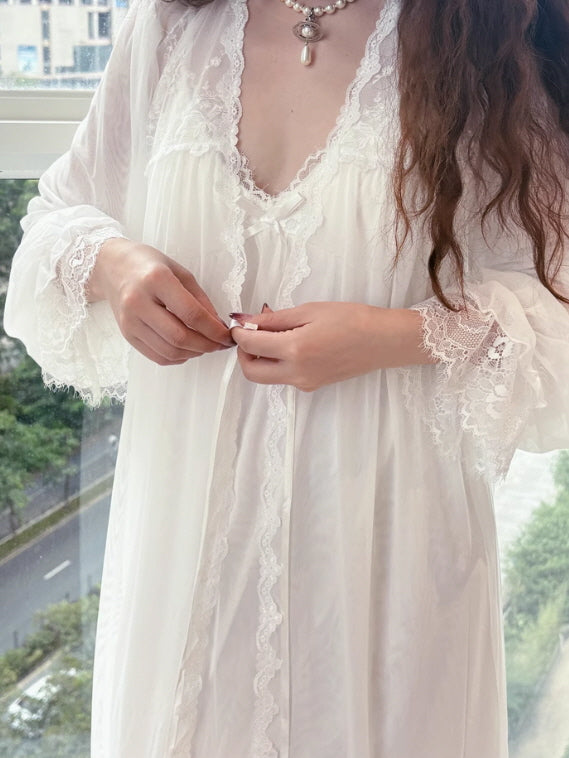Model adjusting the lace trim of a vintage-inspired white gown with flared sleeves, styled in a romantic princesscore aesthetic.
