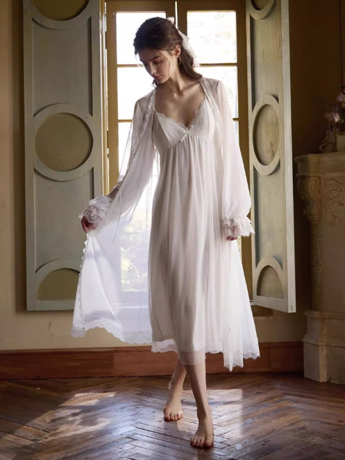 The model steps gracefully through morning light in a dreamy white slip dress and matching robe, evoking a fairycore-inspired aesthetic.