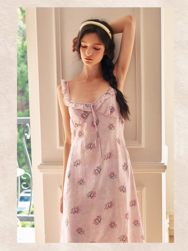 Model poses with one arm raised in a pastel pink floral nightgown, blending soft cottagecore elegance with a dreamy fairytale silhouette.