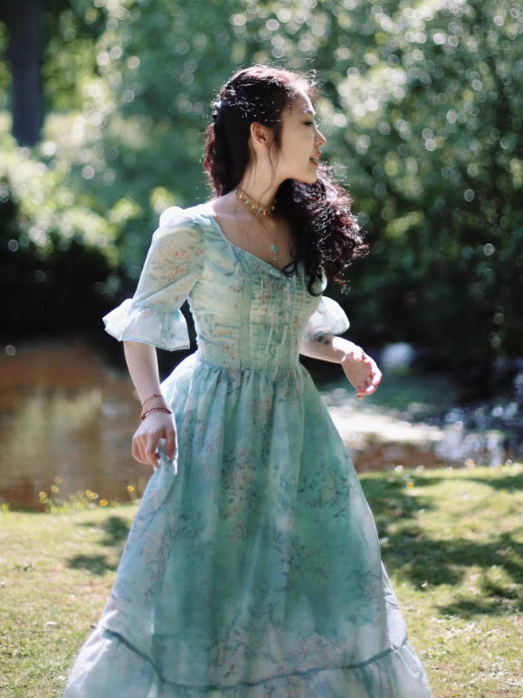 Side view of a Romantic Fairytale vintage-inspired mint floral maxi dress featuring a tie-front bodice, puff sleeves, and a flowing skirt, styled in sunlight for a romantic cottagecore aesthetic outfit.