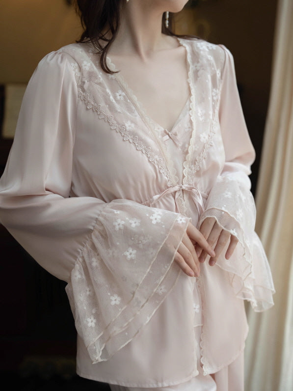 Close-up of blush lace robe with V neckline, floral lace trim and sheer mesh bell cuffs, romantic vintage loungewear detail shot.