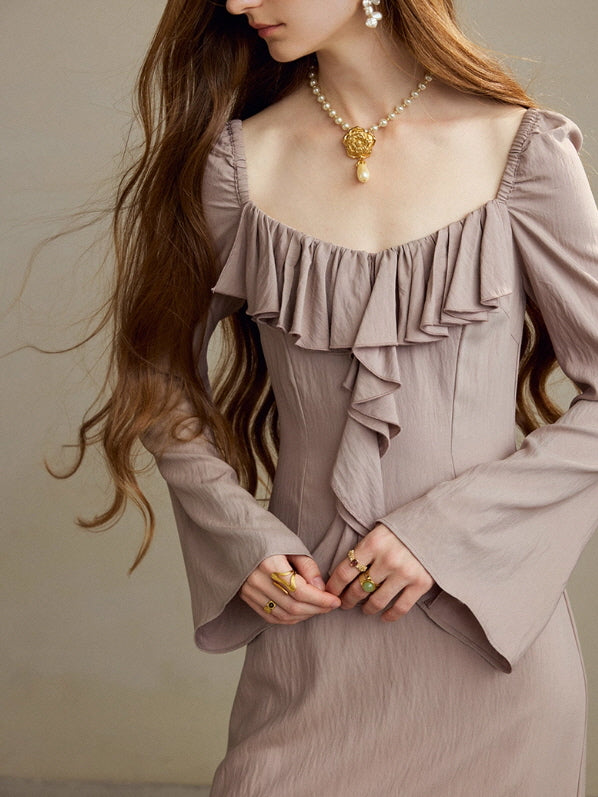 Close-up of a model wearing a taupe ruffle long dress with a vintage square neckline, showing the cascading front ruffles, flared sleeves, and romantic cottagecore styling in a soft fairytale mood.