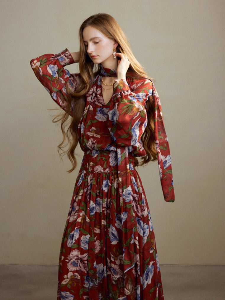 Close-up of a model in a red floral long-sleeve dress with a draped scarf neckline, highlighting the romantic fairycore style and delicate fabric texture.