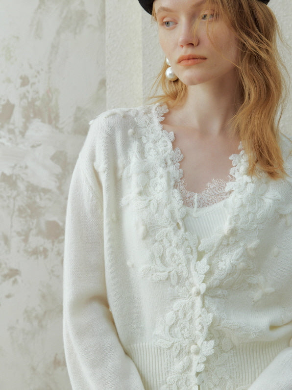 Romantic white lace appliqué cardigan with delicate floral embroidery and V-neckline, styled in a vintage cottagecore aesthetic outfit with soft knit texture.