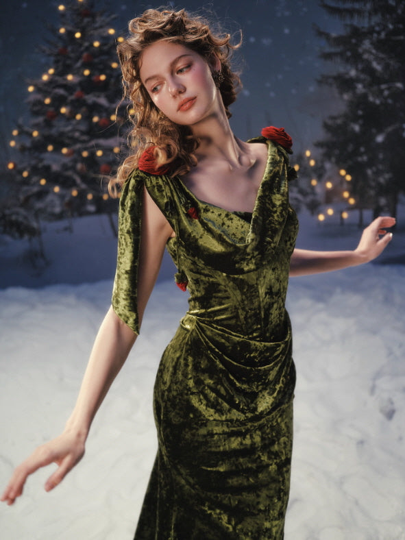 Close-up of an olive green velvet dress with draped bodice and delicate rose accents on the shoulders, capturing a graceful vintage fairytale aesthetic with soft winter lighting.