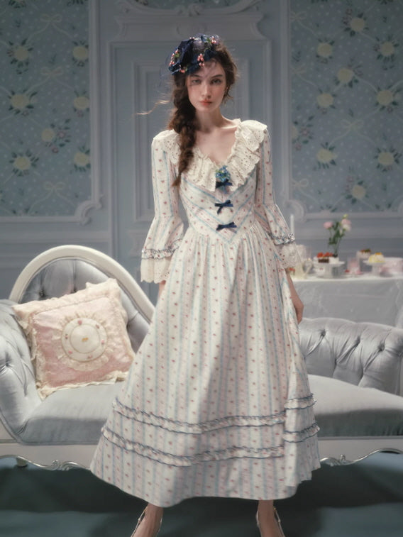 Long vintage-inspired floral dress with a corset-style bodice, lace sleeves, and flowing tiered skirt, creating an elegant fairycore and cottagecore fairytale look.