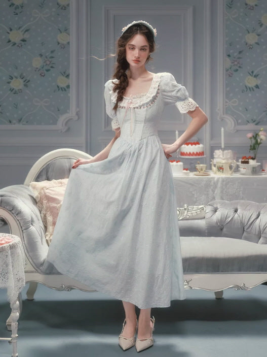 Romantic pale blue lace dress with puff sleeves and a softly fitted bodice, styled in a vintage cottagecore fairytale interior with an elegant, timeless silhouette.