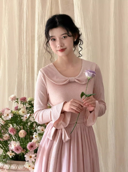 Close-up of a pastel pink vintage knit dress with a sailor collar and flowing skirt, styled as a feminine princesscore and fairytale-inspired aesthetic outfit.