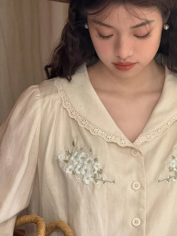Close-up of a cream vintage blouse featuring delicate floral embroidery and lace details, styled as a romantic cottagecore and fairycore aesthetic outfit.