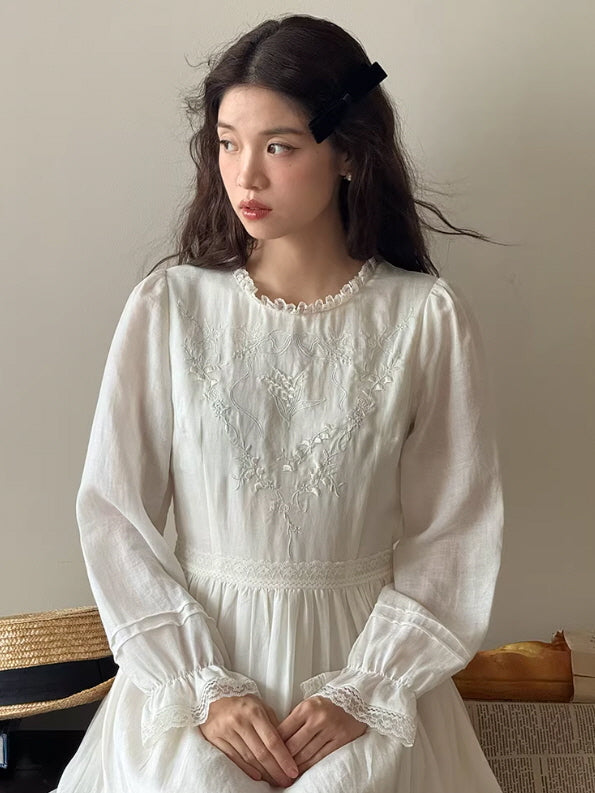 Close-up of a white vintage dress with delicate floral embroidery and lace details, showcasing a soft fairycore and princesscore inspired aesthetic outfit.