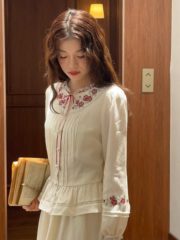 Close-up of a white embroidered vintage blouse with rose floral details, lace trim, and a soft feminine silhouette, styled as a fairycore and cottagecore aesthetic outfit.