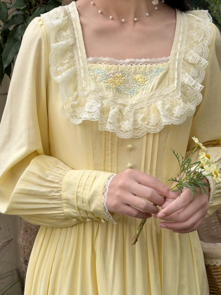 Close-up detail of lace trimmed square neckline with floral embroidery on a vintage inspired cottagecore dress