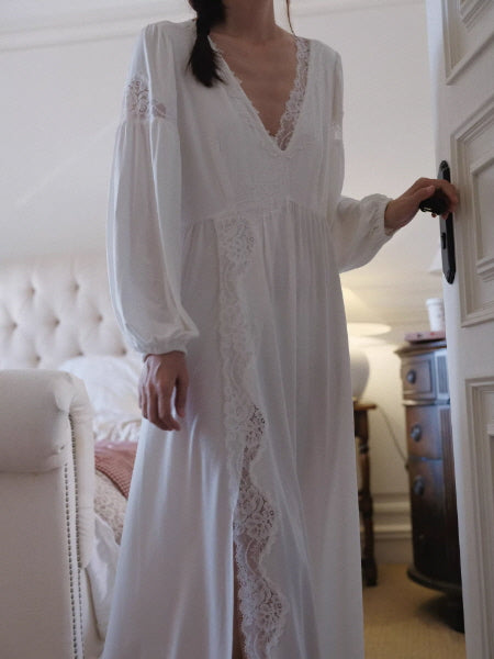 Elegant white lace-trim nightgown with long sleeves and V-neck, soft flowing cotton fabric, romantic bedroom setting