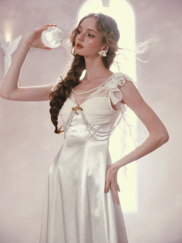 Fairycore ivory dress with pearl chains and lace bodice, holding crystal orb, dreamy vintage aesthetic outfit