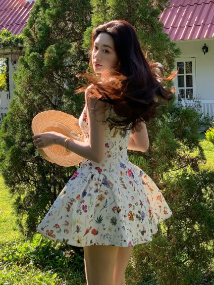 Ivory floral fairycore sundress with fit-and-flare silhouette, shown from the back in a sunny cottage garden