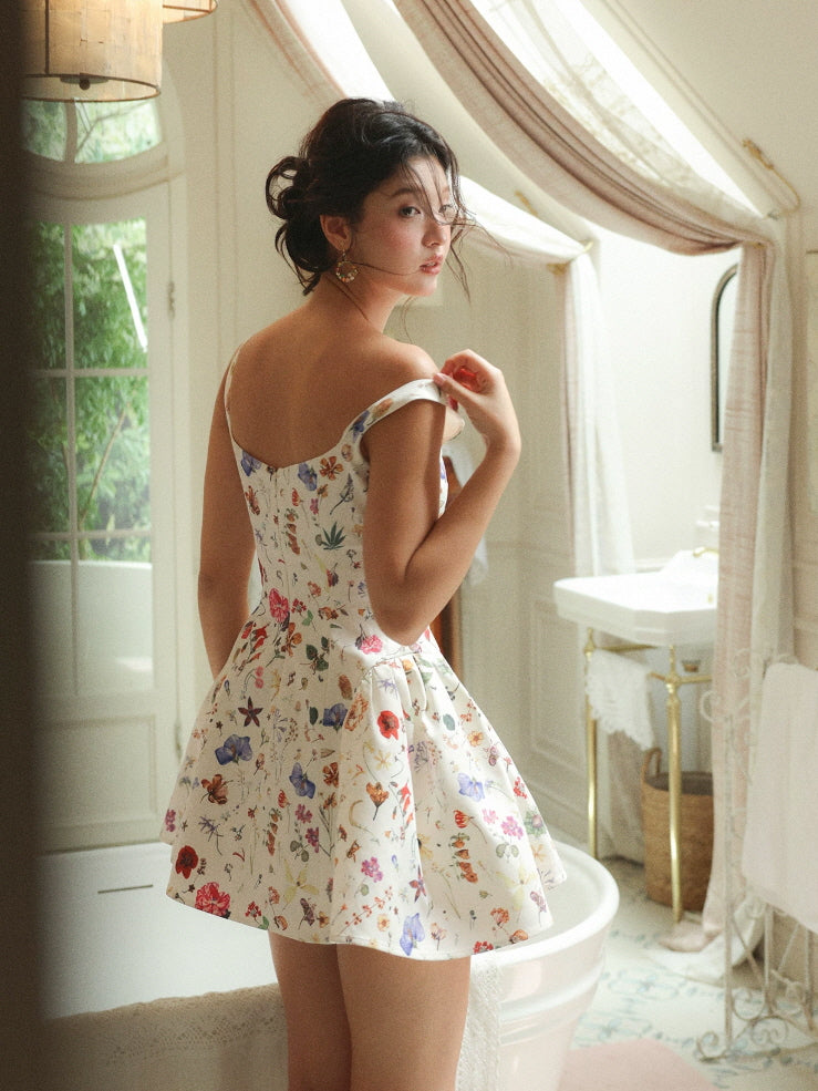 Back view of an ivory floral fairycore mini dress with fitted waist and flared skirt in a soft vintage bathroom scene