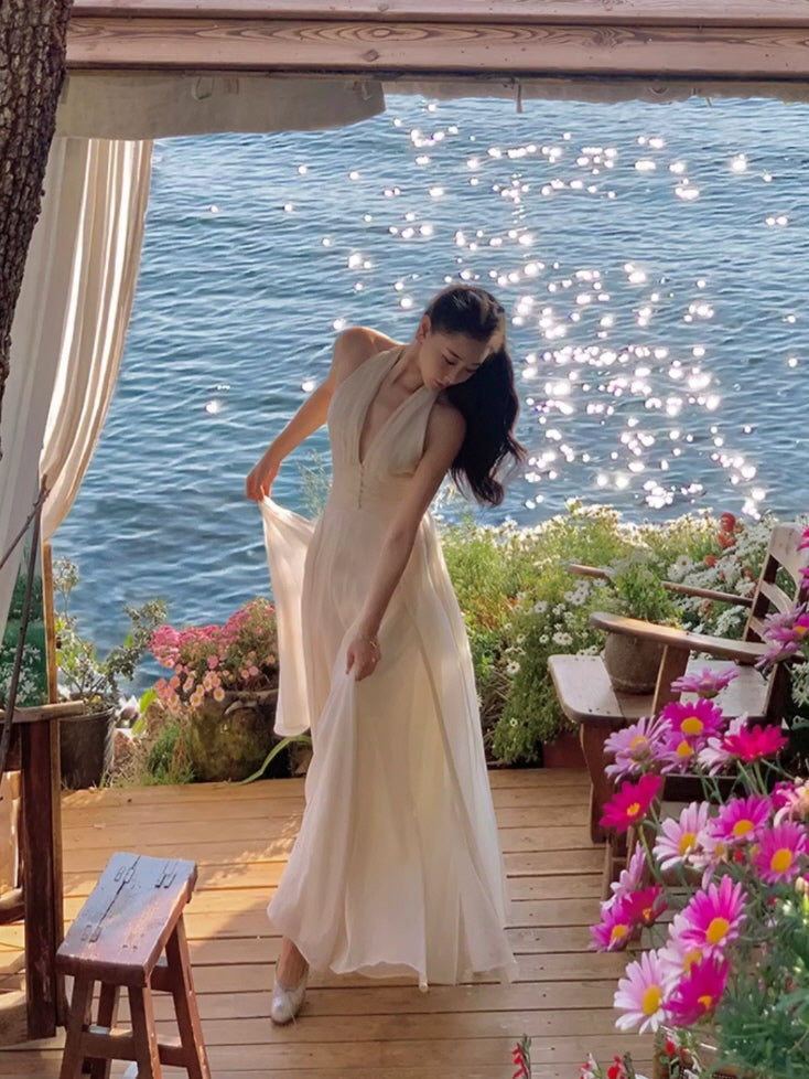 Ivory resort maxi fairycore dress with flowing silhouette on a seaside flower terrace
