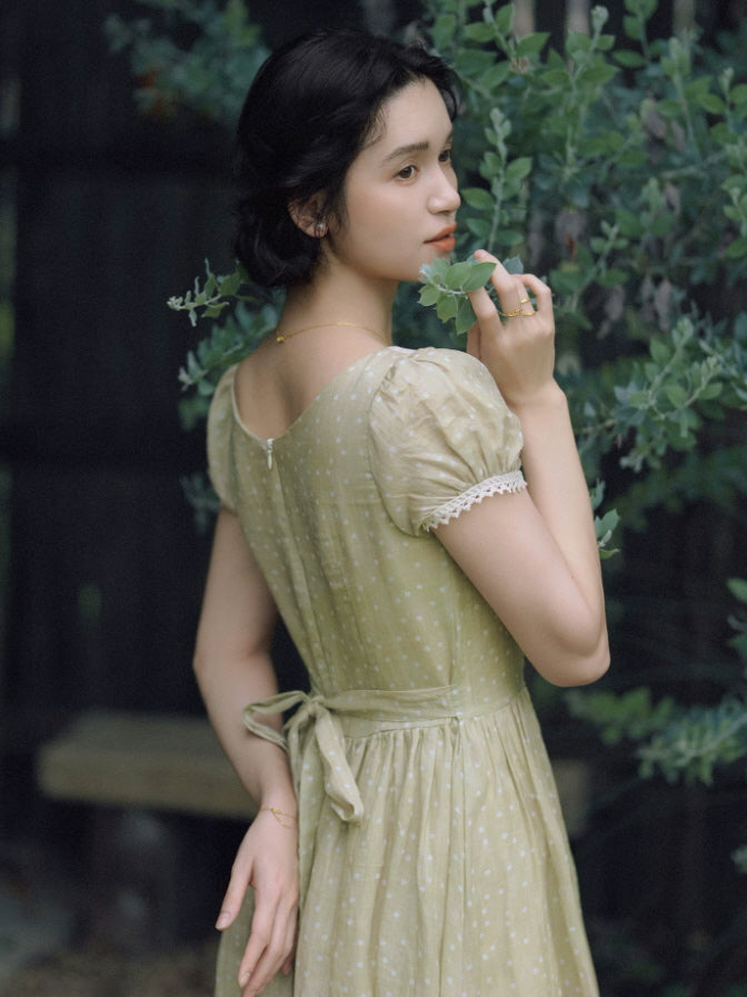 Vintage-inspired green dotted dress with puff sleeves and fitted waist